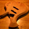 Carved arm bevel and upper horn on a mahogany bass