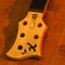 Curly maple headstock and ebony fretboard of a 5 string custom bass