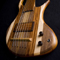 Front of the custom 6 string bass body showing the bridge, pickup cover, and striped body