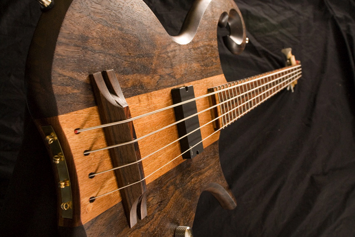 The bass' string thru anchors, bridge, and body from a wide angle