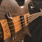 The bass' string thru anchors, bridge, and body from a wide angle