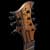 Upper bout of the 7 string guitar showing stripes of the black limba, Hipshot bridge in the background