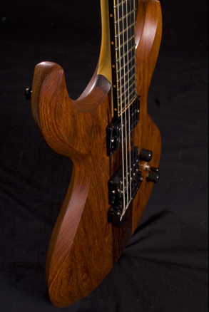 Custom guitar body from the side with unique, hand-carved bevels