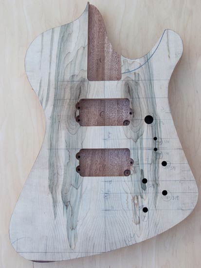 Custom bass body made of mahogany with mineral-stained maple tops