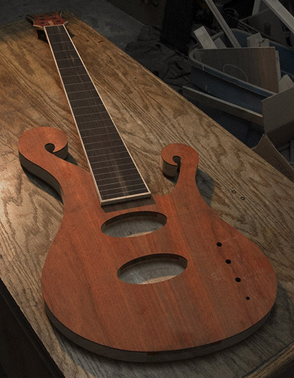 Custom fretless bass guitar with mahogany core, bloodwood tops