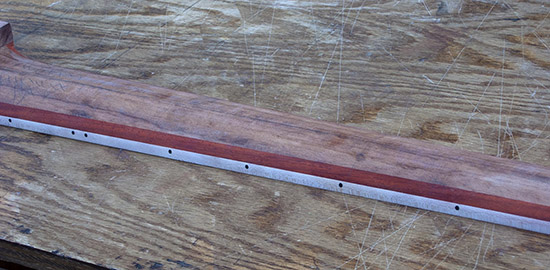 Carved profile of a fretless 6-string bass neck