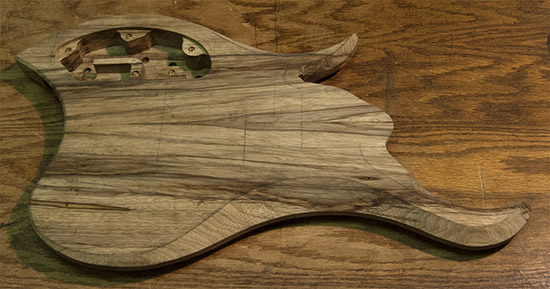 Book matched black limba body of a custom bass guitar