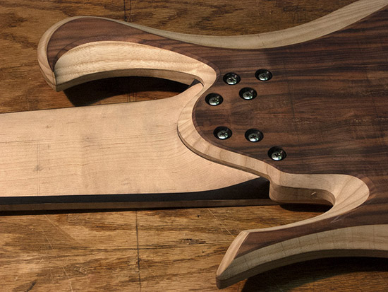 Bolt-on heel of an 8-string bass with threaded inserts