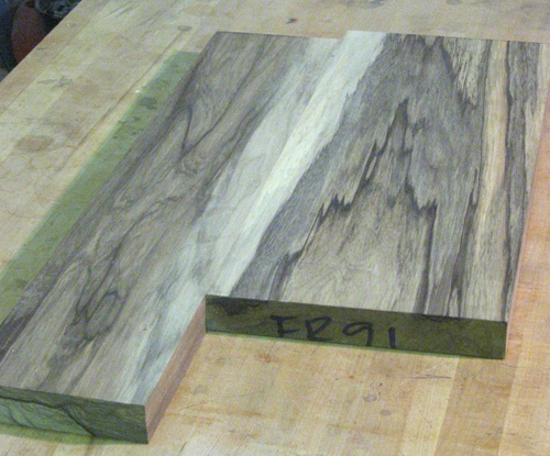 Front of the 7 string guitar's black limba body blank