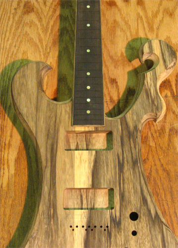 Body, fretboard, scroll and horn of the 7 string guitar from the front after string thru and bridge holes have been drilled