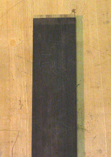 The guitar's ebony fretboard with the nut-side black limba binding glued in place