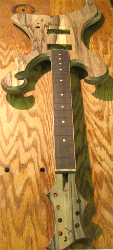 Headstock w/ Xylem logo, black limba bound ebony fretboard and black limba body of the custom guitar from the front