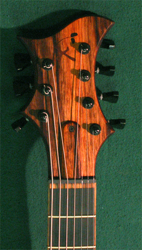 The black limba-veneered headstock of the custom guitar with Hipshot tuners and GraphTech black tusq nut