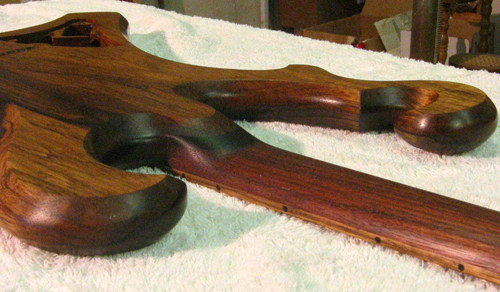 Back of the custom guitar's body, neck, scrolls and fret markers after coats of finish