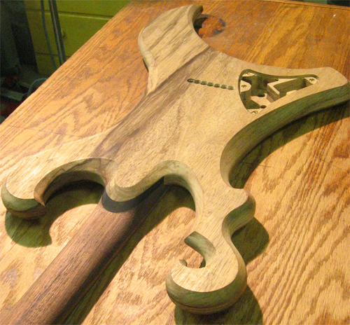 The scroll, ebony neck shim, body and neck of the custom guitar from the back