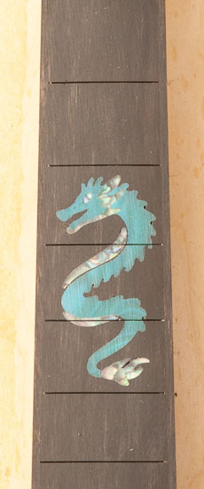 Green dragon inlay with abalone accents in an ebony fretboard